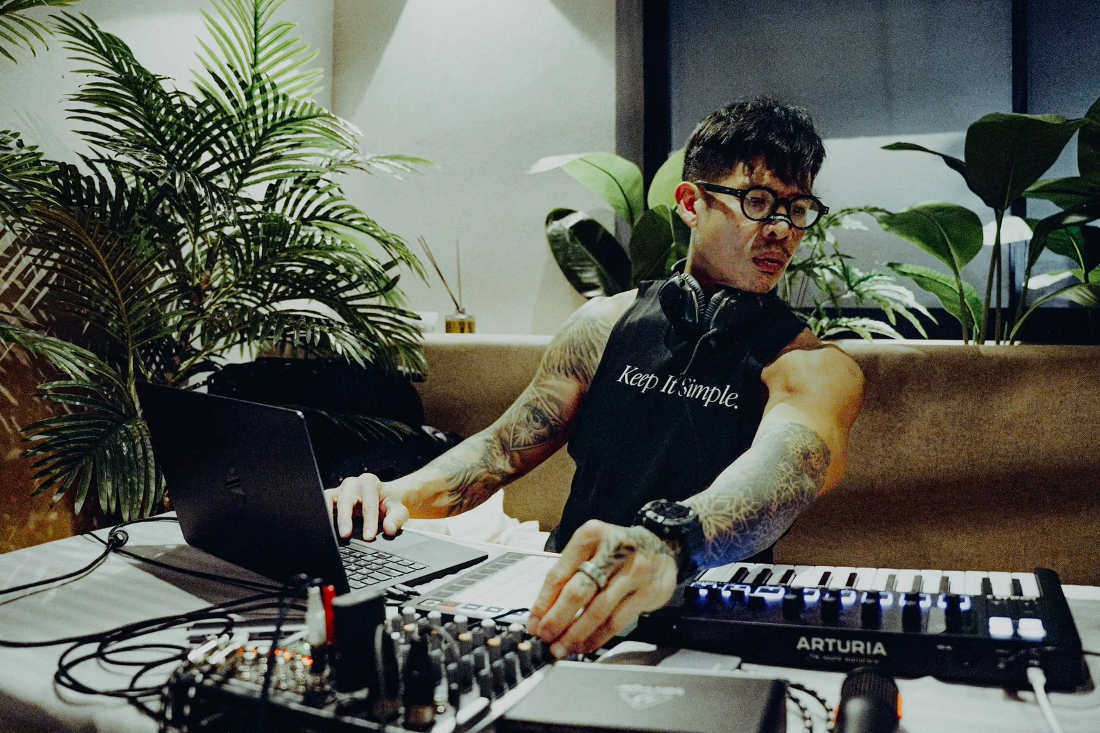 Luke Tan creating music with a laptop, headphones and keyboard